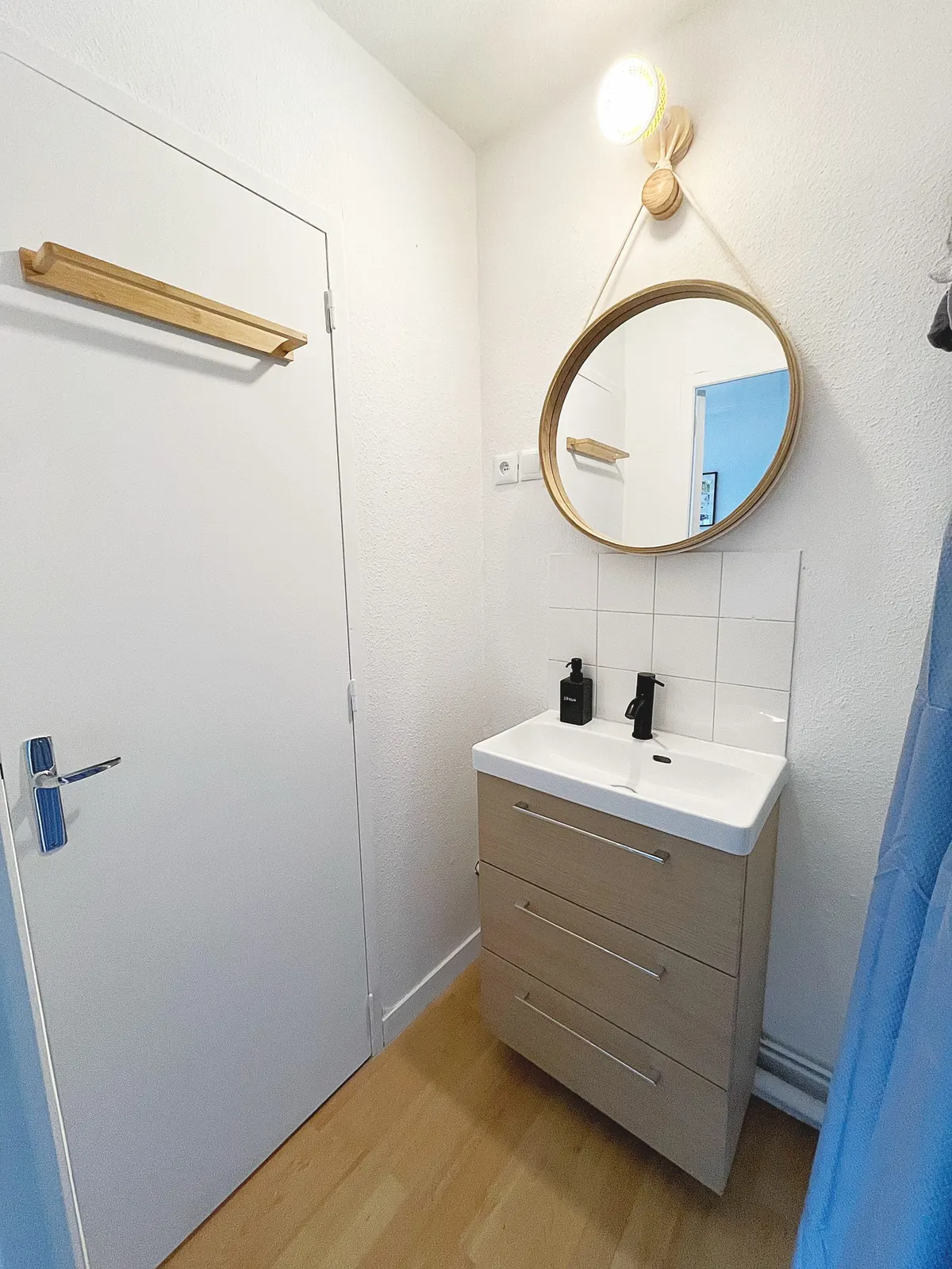 Salle d’eau avec vasque et miroir rond